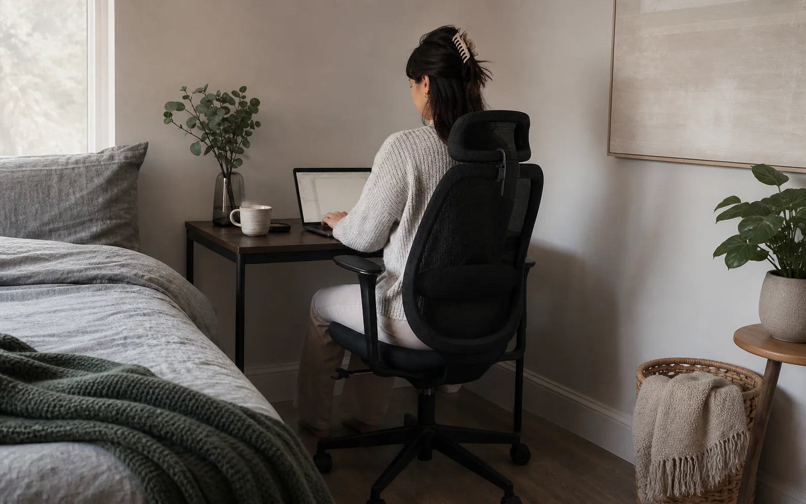 A person trying an OTTUNI ergonomic chair at a home desk